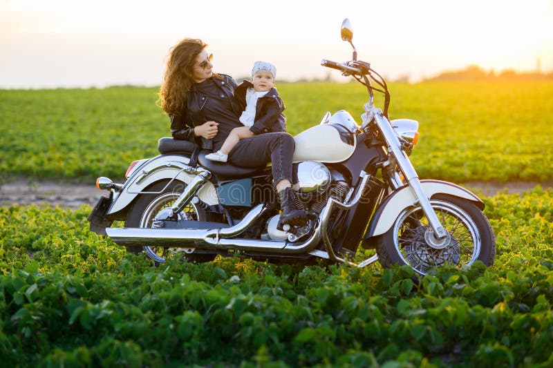 Junge schöne Mutter und kleine Tochter fahren mit dem Motorrad lizenzfreie stockfotografie