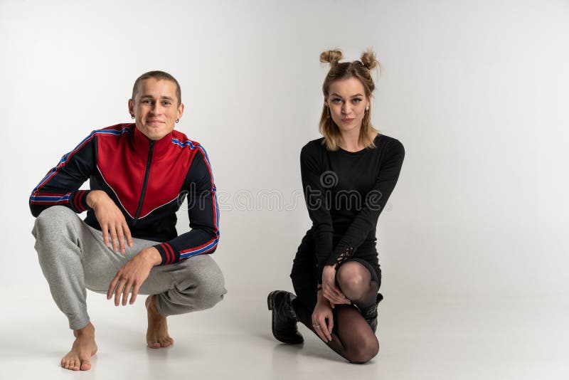 Junge schöne Paare, die auf dem Boden, Studioporträt sitzen stockfotografie Junge schöne Paare, die auf dem Boden, Studioporträt sitzen stockfotografie