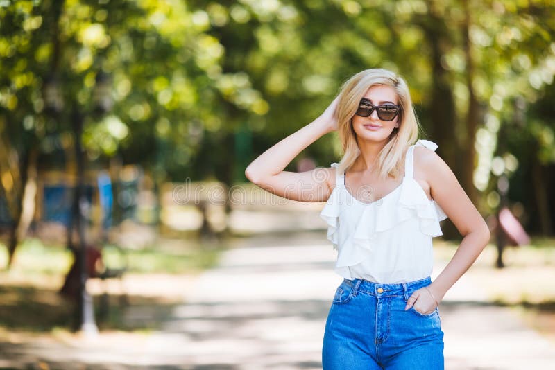 Junge Schönheit in der Sonnenbrille am sonnigen Tag im Park stockfoto Junge Schönheit in der Sonnenbrille am sonnigen Tag im Park stockfoto