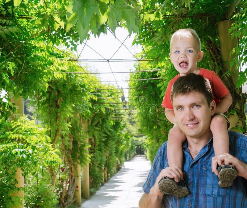 Junge sitzt auf Schulter neben Vater lizenzfreie stockfotografie Junge sitzt auf Schulter neben Vater lizenzfreie stockfotografie