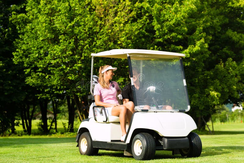 Junge sportive Paare mit Golfwagen auf einem Kurs stockbilder Junge sportive Paare mit Golfwagen auf einem Kurs stockbilder