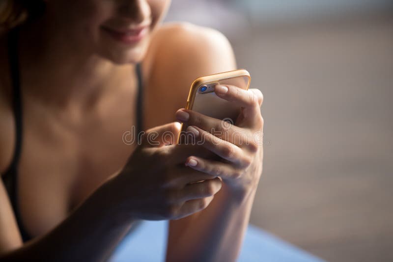 Junge sportliche Frau, die Smartphone, Abschluss hochhält lizenzfreie stockfotos Junge sportliche Frau, die Smartphone, Abschluss hochhält lizenzfreie stockfotos