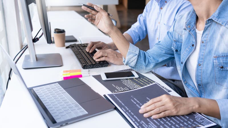 Junge Startup-Programmierer, die an den Schreibtischen arbeiten, auf Computerbildschirmen zur Entwicklung von Programmierung und stockfotos Junge Startup-Programmierer, die an den Schreibtischen arbeiten, auf Computerbildschirmen zur Entwicklung von Programmierung und stockfotos