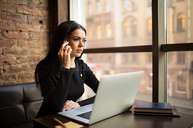 Junge stolze Frau, die erfolgreich Content-Manager ist und während des Online-Schulungskurses auf Laptop-Computern Telefongespräc stockfotos