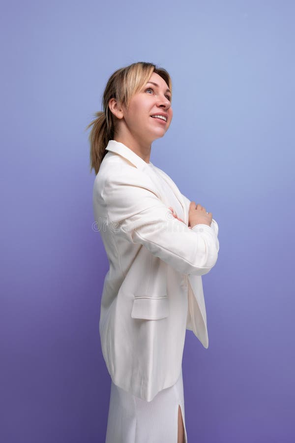 Junge stolze, gut gepflegte blonde Chefin in einer weißen Jacke und Kleid stockfoto