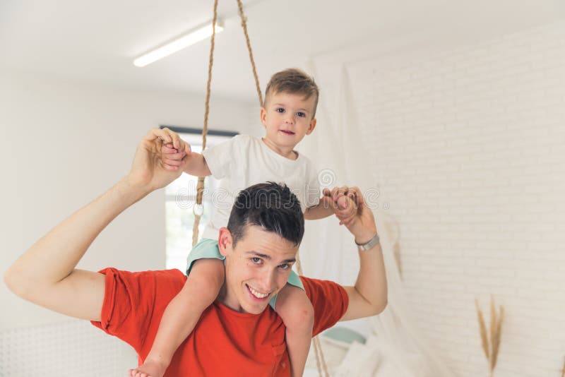 Junge stolze Kaukasier Vater Ferkel unterstützt seinen Vorschuljungen. Beziehung zwischen Eltern und Kind. stockfotografie