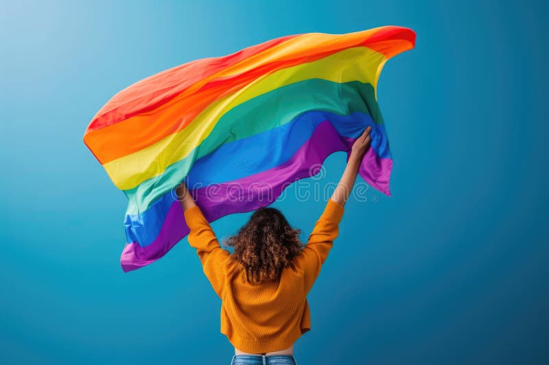 Junge stolze lesbische Frau, die große stolze homosexuelle Fahne verbreitet, mit ihrem Schatten hinter dem Tuch bei der Verteidigu lizenzfreie stockfotos
