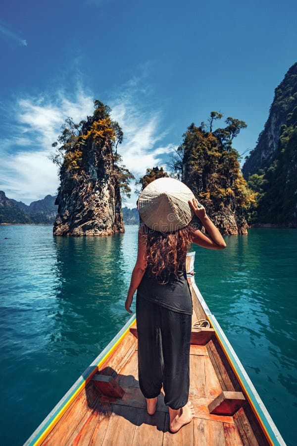 Junge Touristinnen im asiatischen Hut auf dem Schiff am See