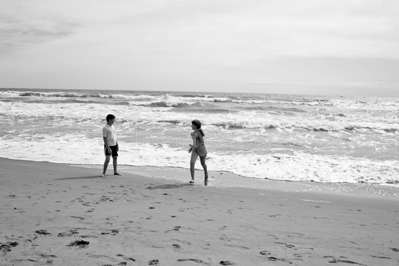 Junge und Mädchen, die auf beatch vor Meer laufen und spielen Sepi lizenzfreie stockfotos Junge und Mädchen, die auf beatch vor Meer laufen und spielen Sepi lizenzfreie stockfotos