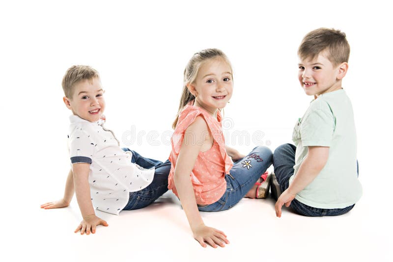 Junge und Mädchen, die über weißem Studiohintergrund aufwerfen lizenzfreie stockfotografie