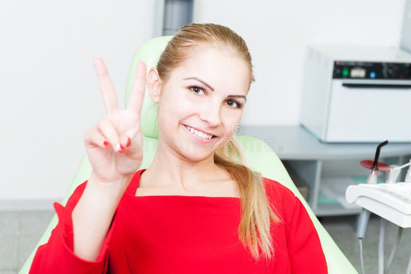 Junge und recht weiblicher Patient am Zahnarzt, der Sieg gestu zeigt stockfoto Junge und recht weiblicher Patient am Zahnarzt, der Sieg gestu zeigt stockfoto