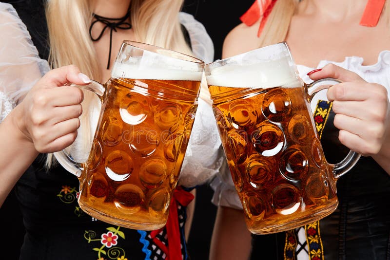 Junge und schöne bayerische Mädchen mit zwei Bierkrügen auf schwarzem Hintergrund stockfotos Junge und schöne bayerische Mädchen mit zwei Bierkrügen auf schwarzem Hintergrund stockfotos