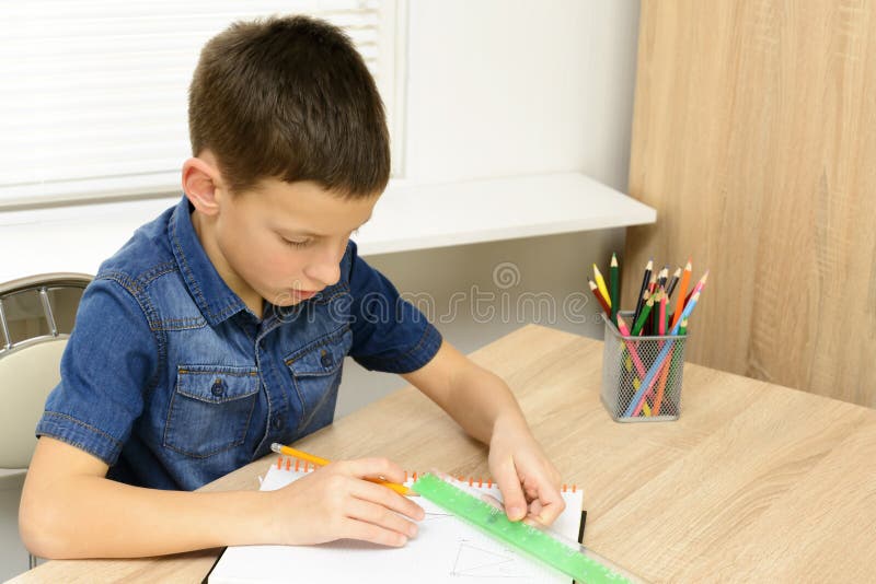 Junge zeichnen Notebook Kind sitzt am Schreibtisch zu Hause und macht seine Hausaufgaben Schule, Kinder, Bildungskonzept stockfoto Junge zeichnen Notebook Kind sitzt am Schreibtisch zu Hause und macht seine Hausaufgaben Schule, Kinder, Bildungskonzept stockfoto