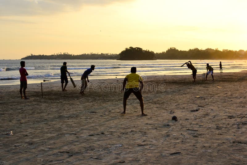 Jungen, die Kricketspiel auf einem Strand spielen stockfoto Jungen, die Kricketspiel auf einem Strand spielen stockfoto