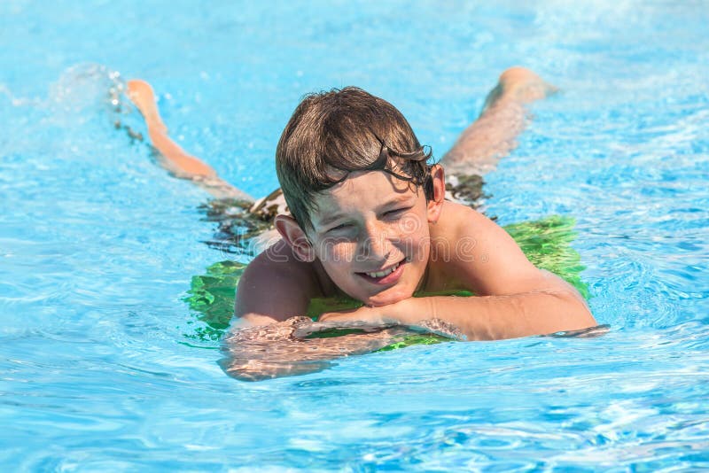 Jungenschwimmen in einem Pool während der Ferien stockbilder
