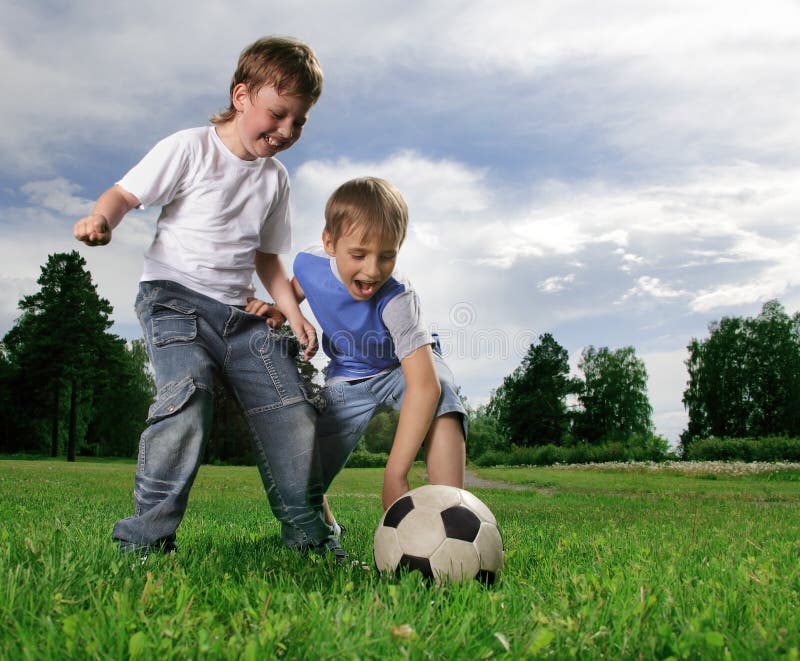 Гулять в футбол играть. Два мальчика играют в футбол. Мальчик играет в футбол. Дети играют в футбол на траве. Мальчишки играют в футбол на траве.