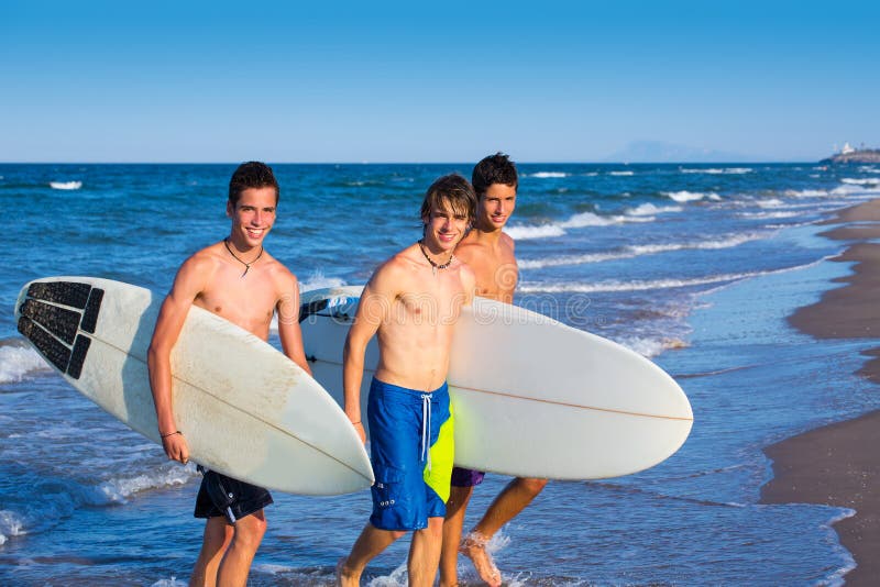 Boys surfers group coming out from blue beach. Boys surfers group coming out from blue beach