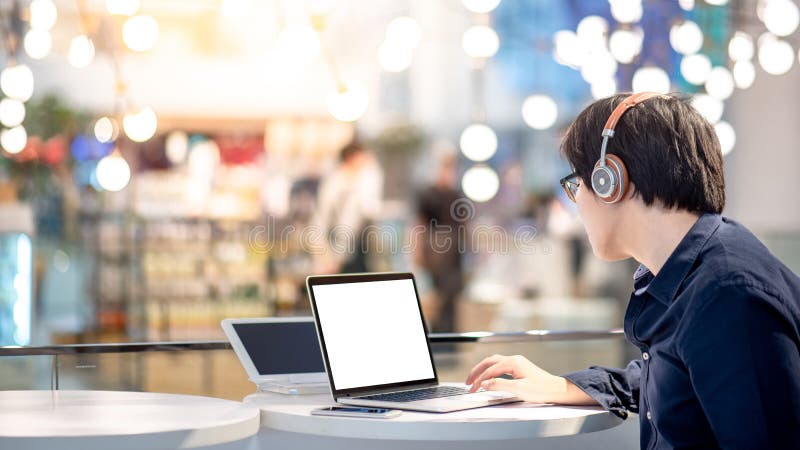 Junger asiatischer Geschäftsmann, der Musik beim Arbeiten mit L hört stockfotografie Junger asiatischer Geschäftsmann, der Musik beim Arbeiten mit L hört stockfotografie