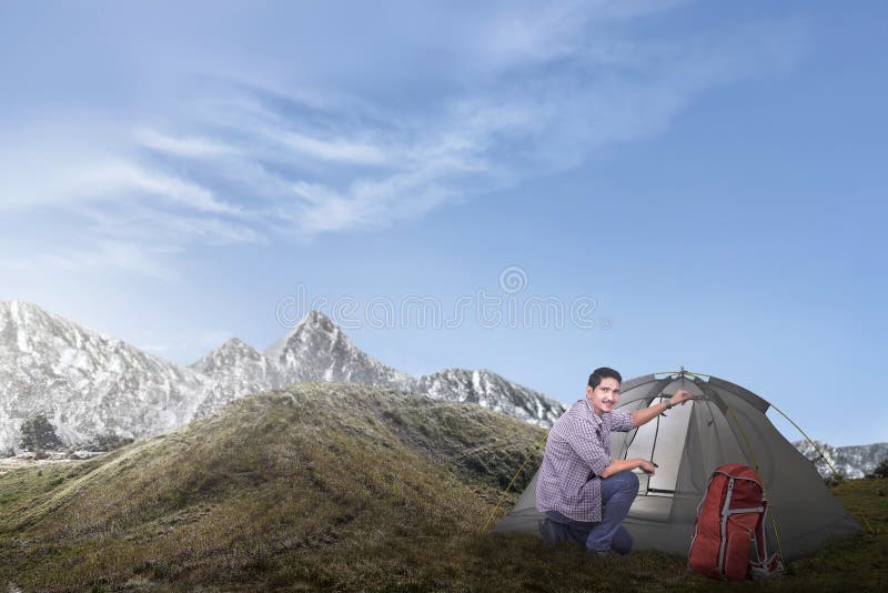 Junger asiatischer Mann gründete ein Zelt lizenzfreie stockfotos Junger asiatischer Mann gründete ein Zelt lizenzfreie stockfotos