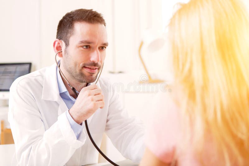 Junger attraktiver hörender Doktor sein Patient lizenzfreie stockfotografie Junger attraktiver hörender Doktor sein Patient lizenzfreie stockfotografie