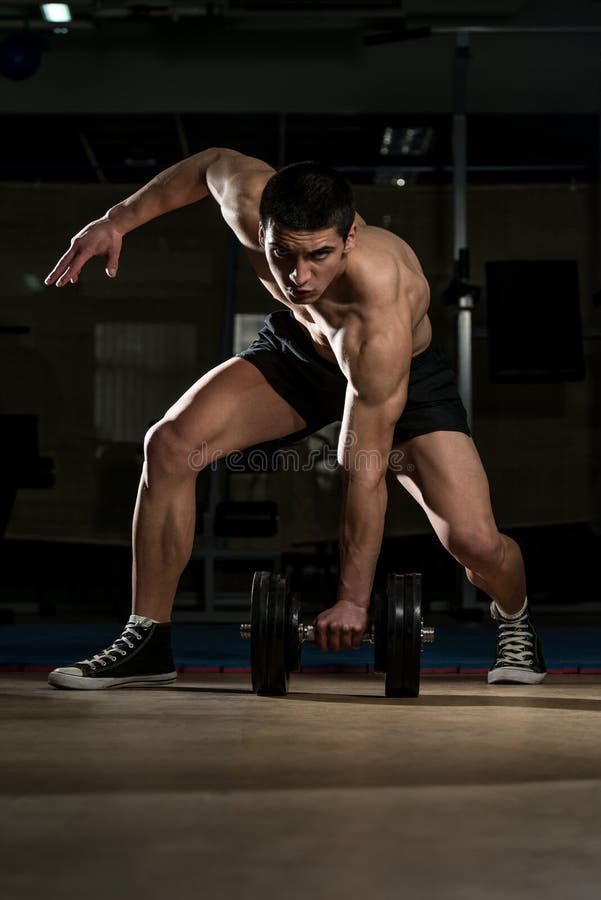 junger bodybuilder lifting heavy dumbbell stockfoto bild von bemühung