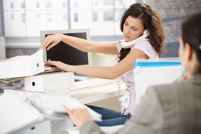 Junger Büroangestellter am Telefon besetzt lizenzfreie stockbilder Junger Büroangestellter am Telefon besetzt lizenzfreie stockbilder