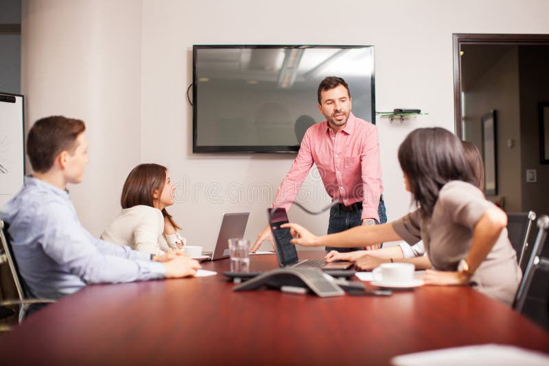 Junger Chef, der mit seinem Team spricht lizenzfreies stockfoto Junger Chef, der mit seinem Team spricht lizenzfreies stockfoto