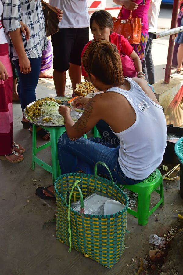 Junger einzelner Straßenrandverkäufer, der lokale Lieblingssnäcke außerhalb Bogyoke-Marktes in Rangun, Myanmar zubereitet u. verk stockfotos