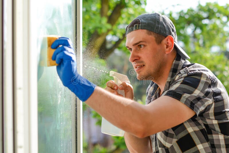 Junger Fensterputzer Mit Einem Sprayreinigungsmittel Auf Glas Stockfoto -  Bild von firma, reinigungsmittel: 117254302