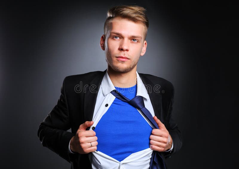 Junger Geschäftsmann, der wie ein Superheld fungiert und sein Hemd, auf grauem Hintergrund zerreißt Junger Geschäftsmann stockbilder Junger Geschäftsmann, der wie ein Superheld fungiert und sein Hemd, auf grauem Hintergrund zerreißt Junger Geschäftsmann stockbilder