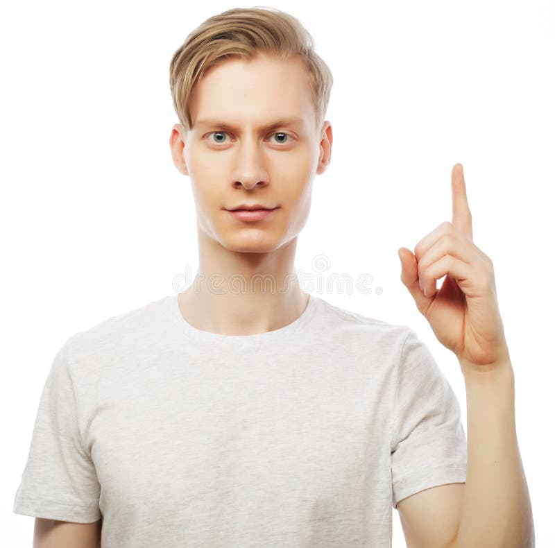 Junger glücklicher Mann mit guter Idee unterzeichnen herein zufällige schauende Kamera lizenzfreies stockbild Junger glücklicher Mann mit guter Idee unterzeichnen herein zufällige schauende Kamera lizenzfreies stockbild