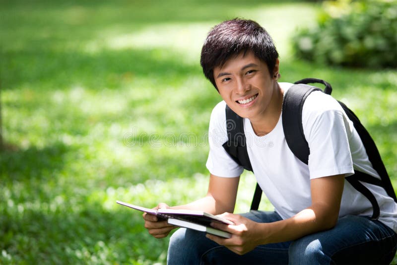 Junger hübscher asiatischer Student mit Laptop