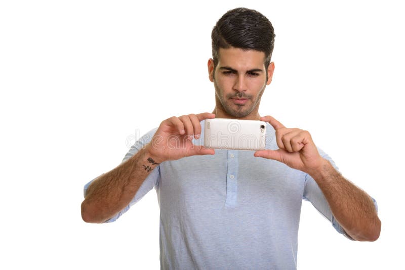 Junger hübscher persischer Mann, der Foto mit Handy macht stockbild Junger hübscher persischer Mann, der Foto mit Handy macht stockbild