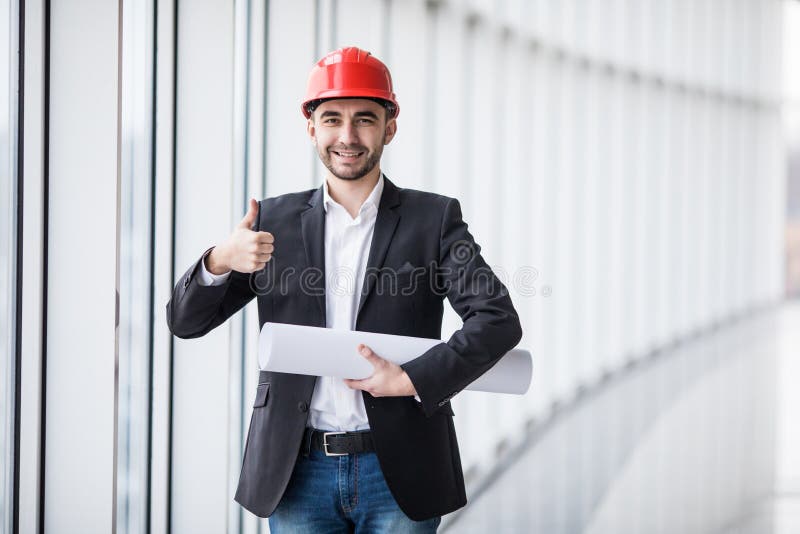 Junger Ingenieur mit den Daumen oben zuhause nahe panoramischen Fenstern stockbilder Junger Ingenieur mit den Daumen oben zuhause nahe panoramischen Fenstern stockbilder