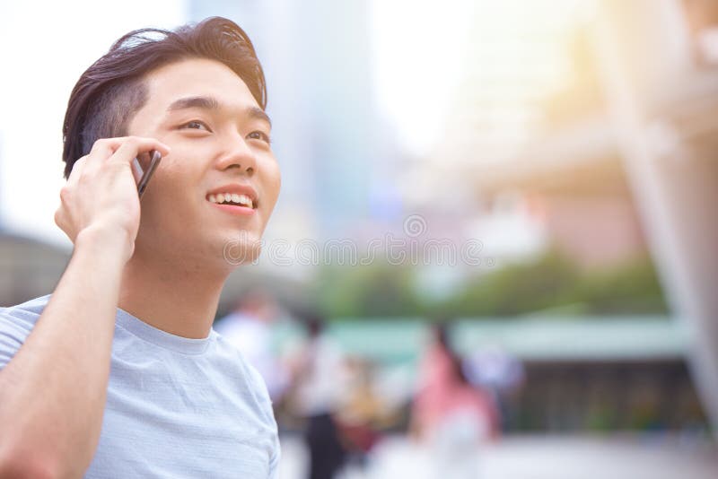 Junger intelligenter asiatischer männlicher jugendlich nennender Telefonanruf lizenzfreie stockfotos Junger intelligenter asiatischer männlicher jugendlich nennender Telefonanruf lizenzfreie stockfotos