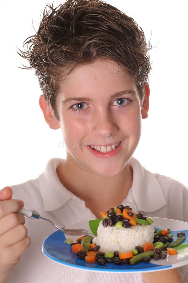 Junger Junge, der gesundes Reis, Bohnen u. Veggies ver isst