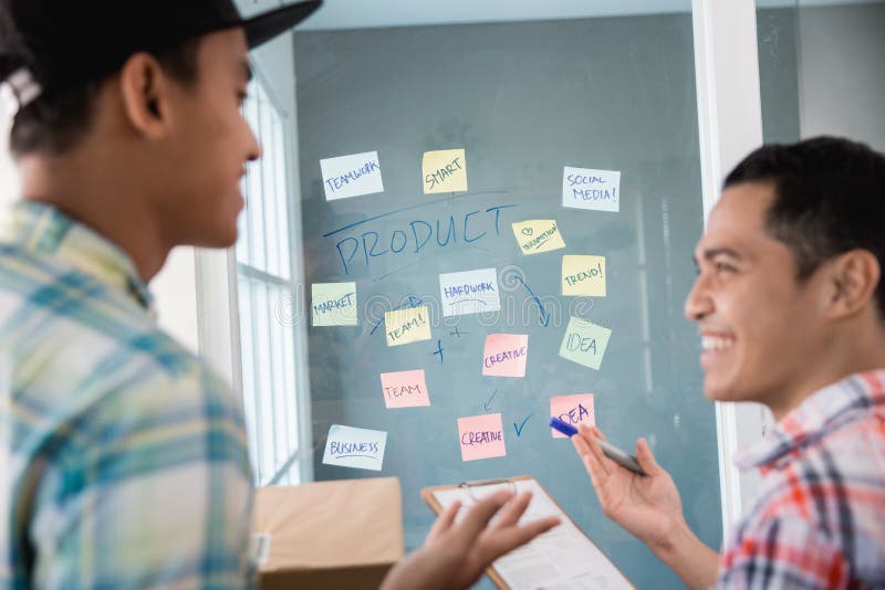 Junger Mann, den Arbeitskräfte Geste dialogieren, erhielt ungefähr einige Ideen, den Bürozielverkauf zu erhöhen lizenzfreies stockbild
