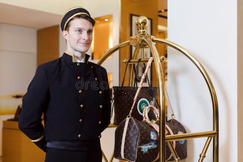 Junger Mann in der einheitlichen Umhüllung im Hotel lizenzfreie stockfotos Junger Mann in der einheitlichen Umhüllung im Hotel lizenzfreie stockfotos