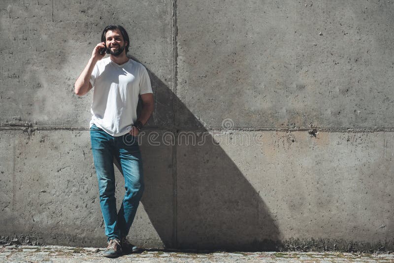 Junger Mann, der Gerät auf der Straße für Kommunikation verwendet lizenzfreie stockfotografie Junger Mann, der Gerät auf der Straße für Kommunikation verwendet lizenzfreie stockfotografie