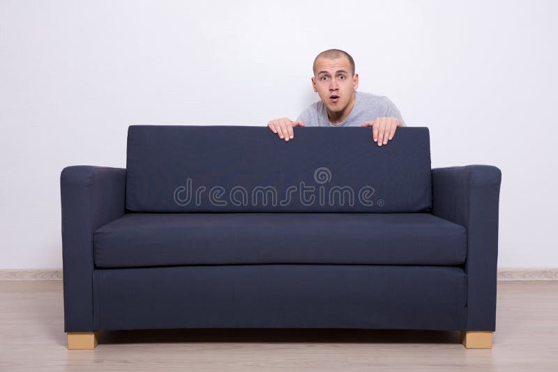 Junger Mann, Der Hinter Einem Sofa Sich Versteckt Stockfoto - Bild von  hintergrund, couch: 63649012