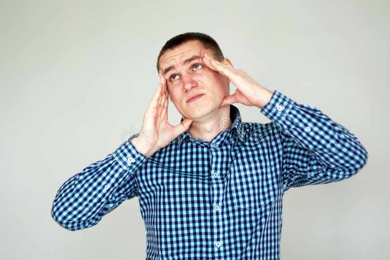 Junger Mann, der Kopfschmerzen hat auf Grau lizenzfreies stockbild Junger Mann, der Kopfschmerzen hat auf Grau lizenzfreies stockbild