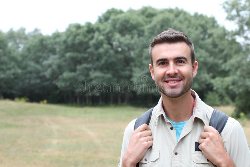 Junger Mann, der lächelndes glückliches Portrait wandert Männlicher Wanderer, der in Wald geht