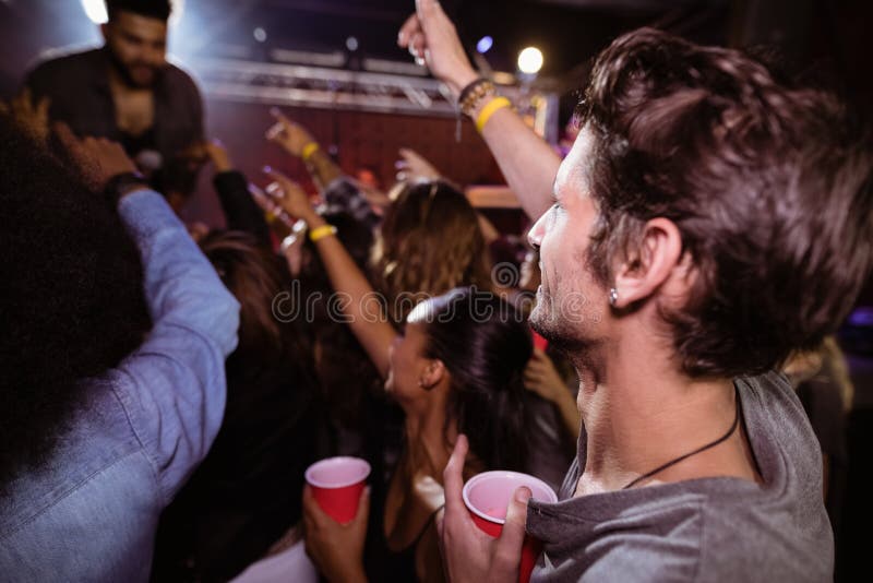 Young men enjoying music concert at nightclub. Young men enjoying music concert at nightclub