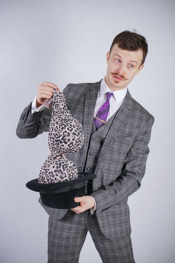 Junger Mann in einem Anzug zieht Leopard-BH von seinem Hut aus, aber er wünschte Tricks mit Wunder und Reichtum emotionaler Mann lizenzfreie stockbilder Junger Mann in einem Anzug zieht Leopard-BH von seinem Hut aus, aber er wünschte Tricks mit Wunder und Reichtum emotionaler Mann lizenzfreie stockbilder
