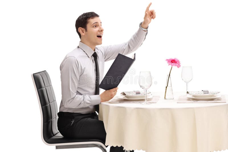 Junger Mann gesetzt an einem Restauranttisch, der den Kellner anruft