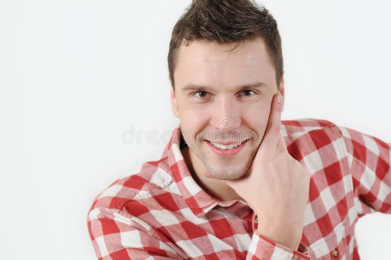 Junger Mann im Hippie-Hemd, das Hand auf Kinn und Stellung gegen weißen Hintergrund hält stockfoto Junger Mann im Hippie-Hemd, das Hand auf Kinn und Stellung gegen weißen Hintergrund hält stockfoto