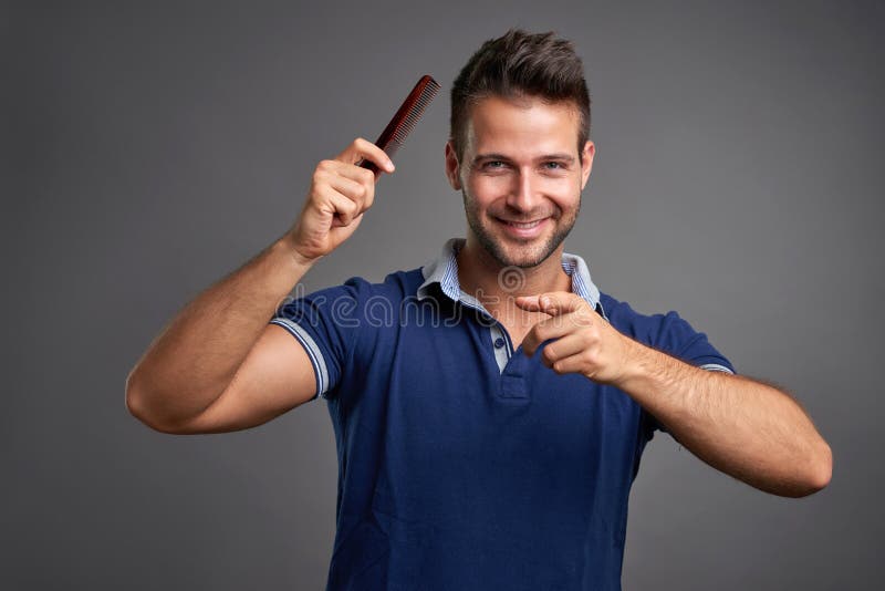 Junger Mann mit Kamm lizenzfreie stockbilder Junger Mann mit Kamm lizenzfreie stockbilder