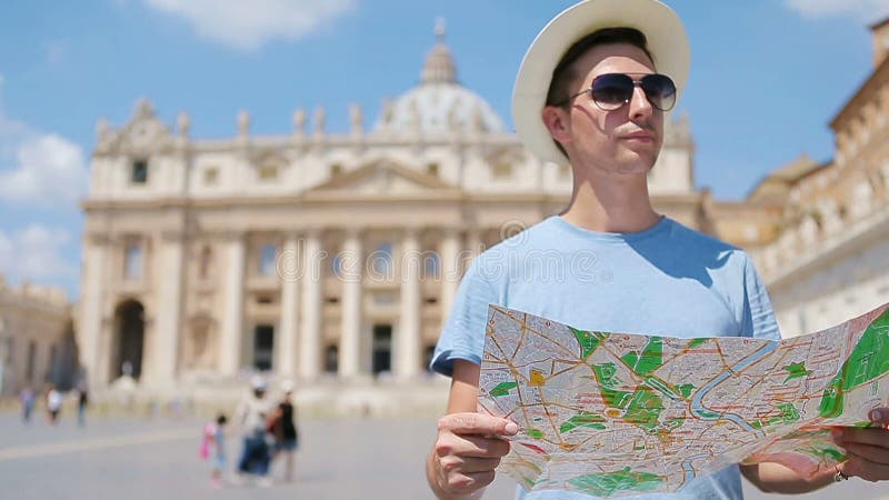 Junger Mann mit Stadtplan in der Vatikanstadt und St Peter in der Basilikakirche, Rom, Italien Touristischer Mann der Reise mit K