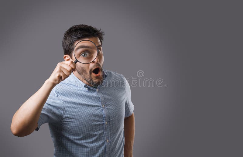 Junger Mann mit Vergrößerungsglas lizenzfreies stockfoto