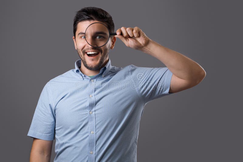 Junger Mann mit Vergrößerungsglas stockfotos